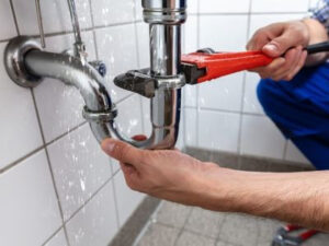 Plumber fixing leaky pipe.